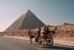 Une calèche avec des touristes passant par les pyramides de Gizeh.