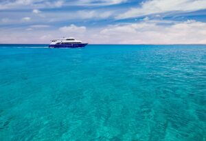 Cruise yacht bow in clear water near a coral reef. Red Sea, Egypt