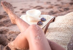 Legs of a woman relaxing on the beach by the sea.