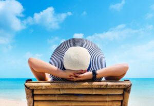 Woman in hat relaxing on the beach, looking at the sea in Orange Bay Hurghada