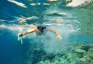 A man with an underwater mask swims in the Red Sea