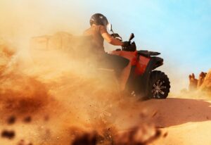 Atv riding in sand quarry, dust clouds, quad bike