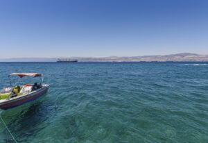 Boat moored in the Red Sea, Jordan, with coastline in the distance.