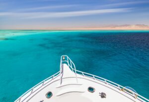 Cruise yacht bow in clear water near a coral reef. Red Sea, Egypt
