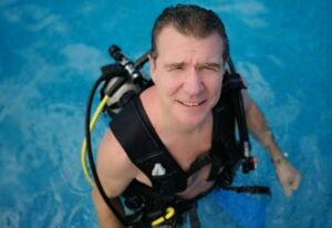 Man is wearing scuba gear, ready for adventure and water fun activity, travel, active seniors