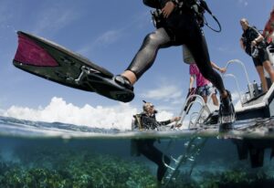 Scuba diver enters water from boat via giant stride entry.,Off to an adventure.