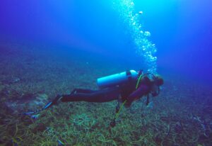 Underwater scuba diving selfie shot with selfie stick. Deep blue sea. Wide angle shot.