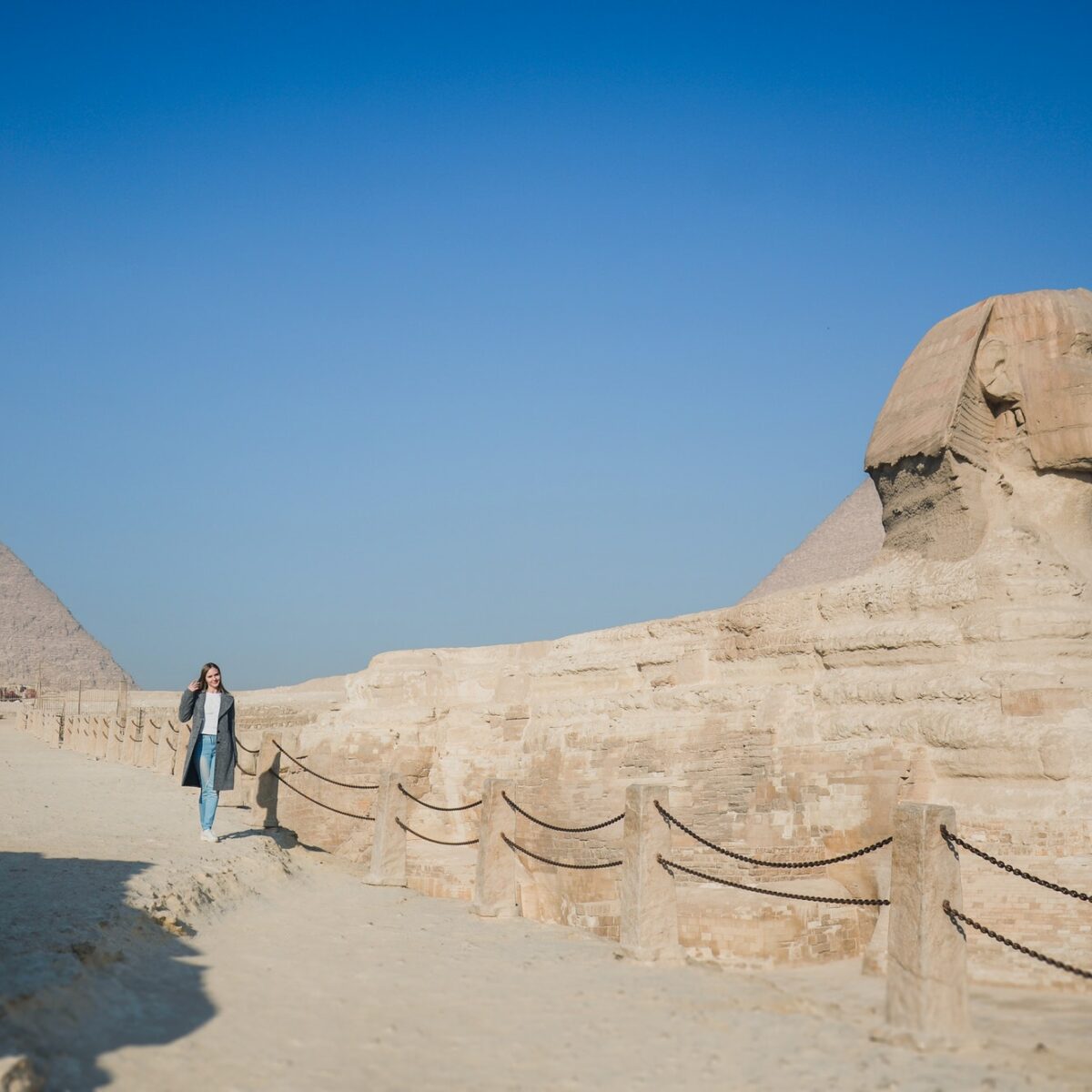 A European blonde walks near the pyramids in the desert in Cairo